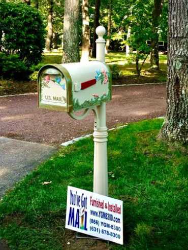 A mailbox with a sign in front of it.