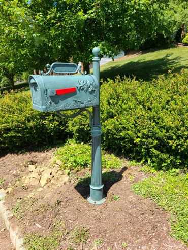 A mailbox in the middle of a grassy area.