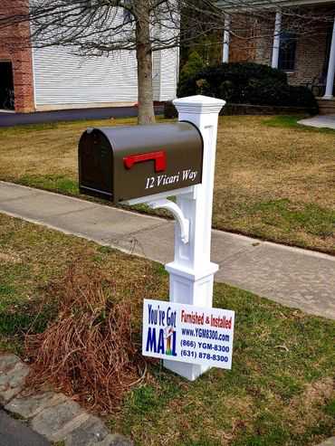 A mailbox with a sign on it in front of a house.