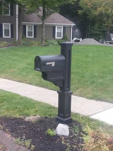 A black mailbox in front of a house.