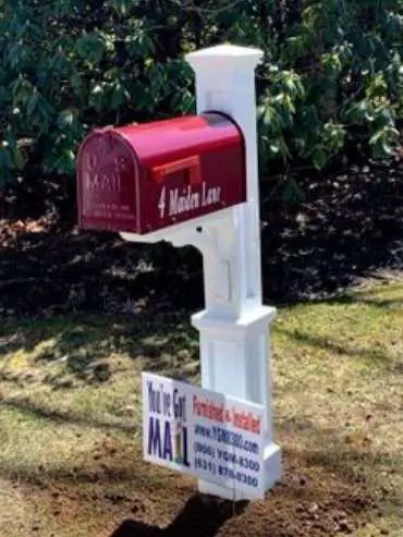 A mailbox with a sign in front of it.