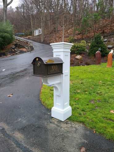 A white mailbox in the middle of a road.
