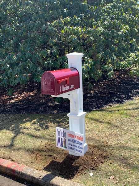 A Janzer Mailbox With Mayne Newport Plus Post, Mailbox Lettering And Installation with a sign in front of it.