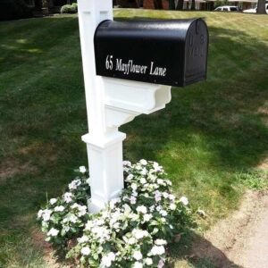 A Janzer Mailbox With Mayne Dover Post, Mailbox Lettering And Installation with flowers in front of it.