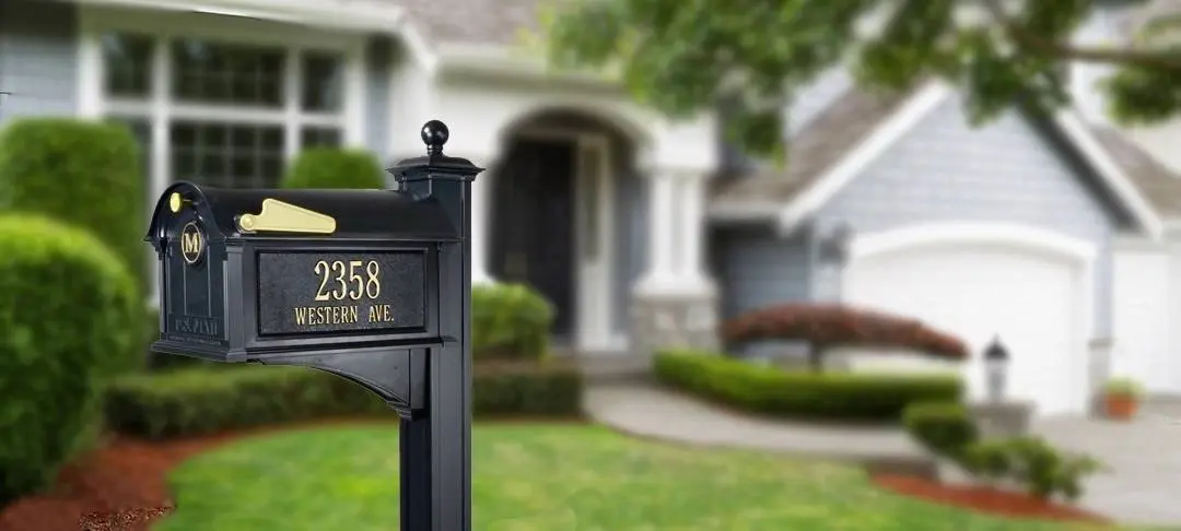 A black mailbox in front of a house.