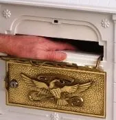 A person opening a Gaines Classic Mailbox With Polished Brass Accent - Installation Included with an eagle on it.
