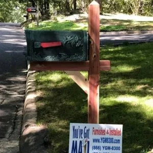 A Cedar Mail Post With Special Lite Mailbox & Installation with a sign in front of it.